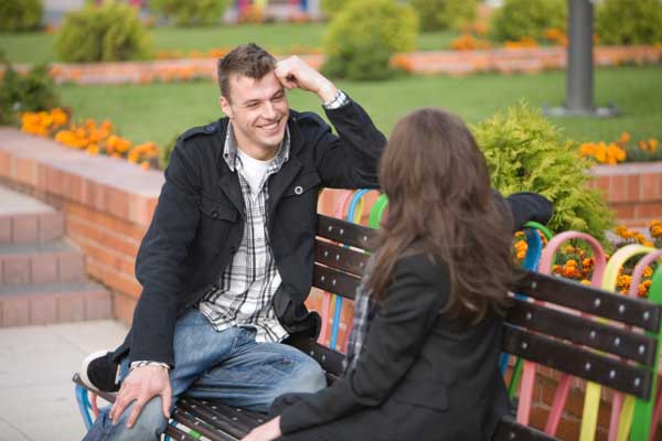 Man and woman on park bench talking